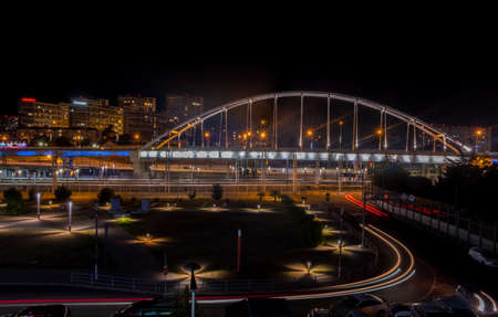 Sochi, Russia - September 11, 2020: modern road bridge and trains near the railway station in Adler night view.のeditorial素材