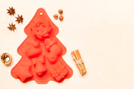 Silicone mold and spices for cooking christmas cookies on wooden background with copy space.