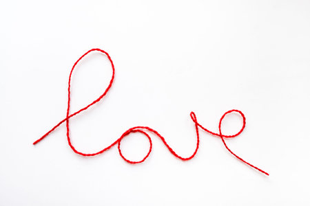 Valentine's day concept. Red heart and word love made from woolen rope on white background with copy...