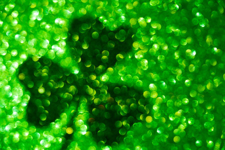Saint patrick's day shade of clover leaf on green bokeh background.