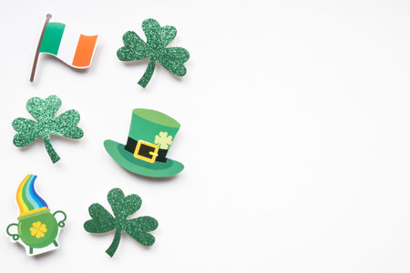 Shamrocks and St Patricks Day symbols on white background with copy space.