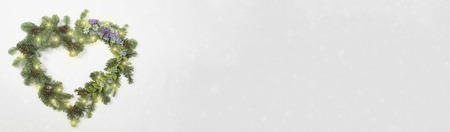 Christmas wreath in heart shape with flowersの写真素材