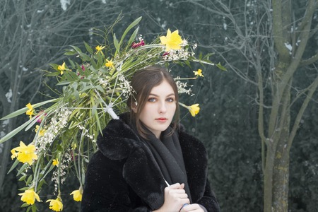 Girl holding a flower umbrella in gardenの写真素材