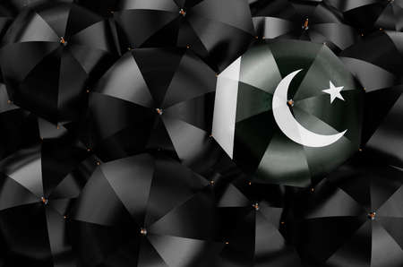 Umbrella with Pakistani flag among black umbrellas, top view. 3D renderingの写真素材
