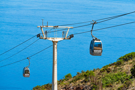 Cable car gondolas over sea and hillside, photoの写真素材
