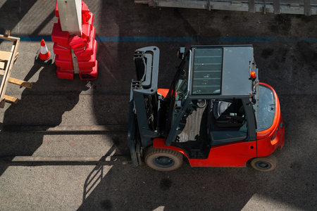 Top-down view of a red forklift truck on an industrial yard