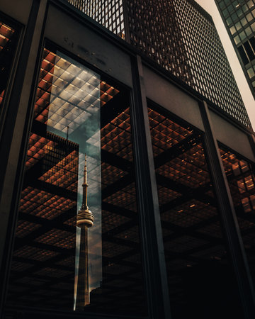 The CN Tower in Toronto reflected in the window of a nearby building.の写真素材