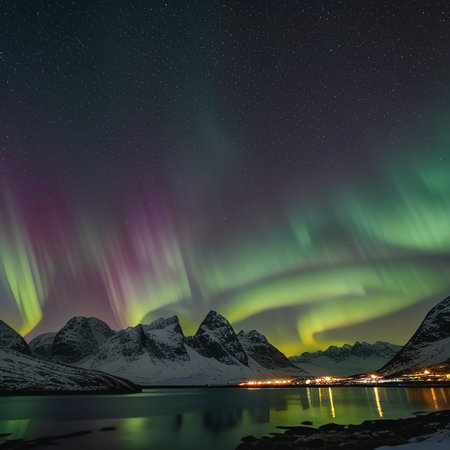 Green and purple aurora borealis over snowy mountains. Northern lights in Lofoten islands, Norway. Starry sky with polar lightsの素材