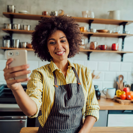 Young woman having a good day, taking a selfie in the kitchenの素材