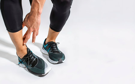 Runner sportsman holding ankle in pain with Broken twisted joint running sport injuryの素材