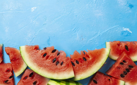 Slices of juicy red watermelon on blue. Top view, flat layの素材