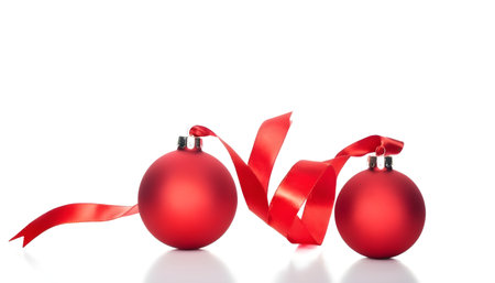 two red christmas decoration balls with satin ribbon, isolated on white backgroundの素材