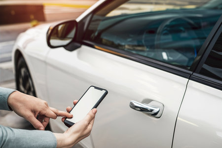 Hand using phone to lock carの素材