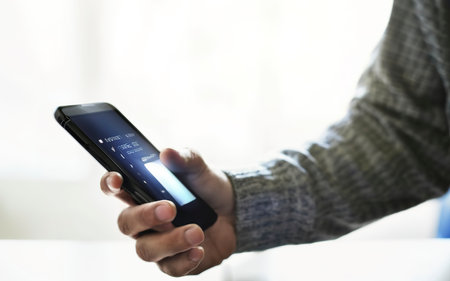 hands holding and texting in a smartphone with back light and copy spaceの素材