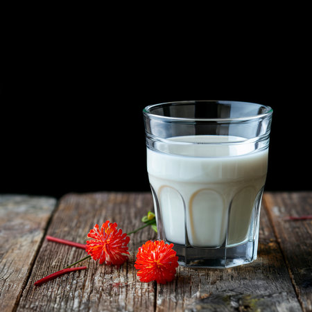 Fresh homemade milk on the table in a glass. On a black backgroundの素材