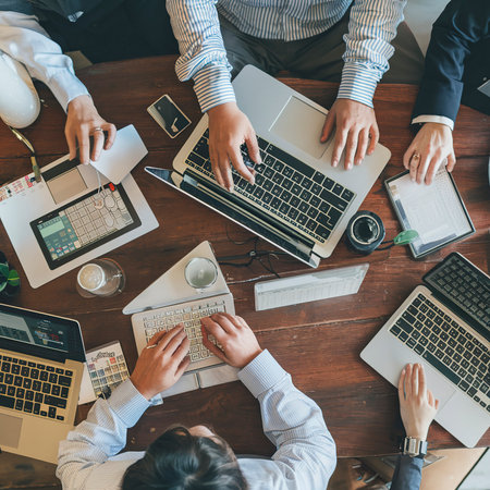 Business people are hand typing on silver color laptop computer put on tableの素材