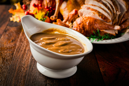 Homemade gravy in a sauce dish with turkey for Thanksgiving or Christmasの素材