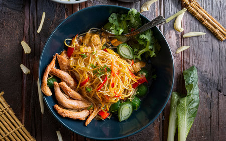 Traditional indonesian meal bami goreng with noodles, vegetables and chickenの素材