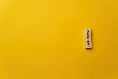 A close-up of an eraser labeled Solutions on a bright yellow background