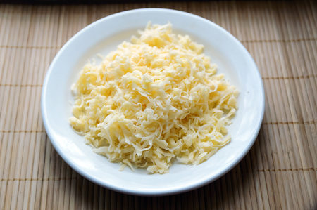 grated cheese on a white plateの写真素材