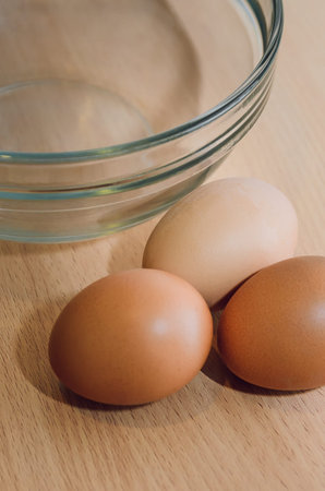 Empty glass dish and three eggs on the table