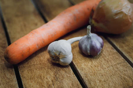 Onions lying on an old wooden kitchen tableの写真素材