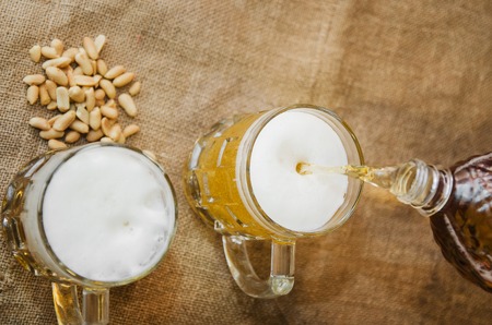 pour beer into a glass from a bottleの写真素材