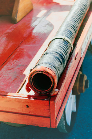 Fire hose on the wooden board of an old red fire truck. Close-up, selective focus.