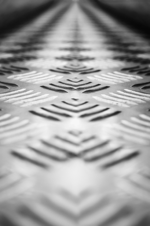 Background of metal with a repeating pattern of bronze color. Close-up, selective focus.の写真素材