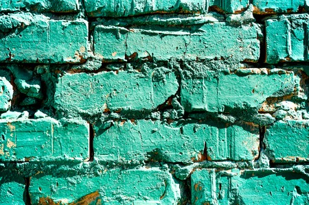 A piece of old painted in turquoise brick wall paint, a brick texture. Abstract background.の写真素材