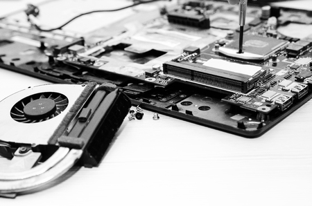 Repair laptops, close-up of hands and dismantled old computer. ?lack and white photography.の写真素材