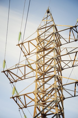 Electric pole with high-voltage wires against the blue sky.の写真素材