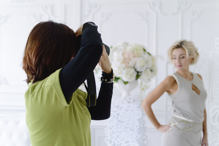A female photographer takes a beautiful model in the studio.の写真素材