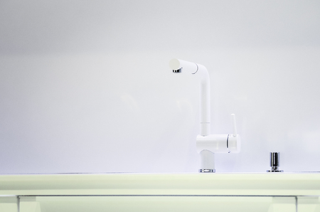 A new white kitchen sink made of artificial stone and a faucet. The concept of modern kitchen interior.の写真素材