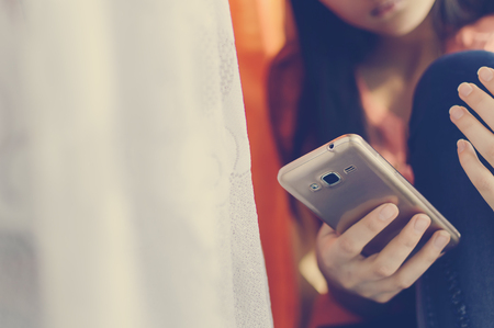 Teen girl holding a mobile phone. Lifestyle style.の写真素材