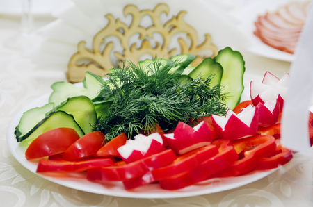 Cucumbers, tomatoes, Bulgarian pepper, radish, herbs. Beautiful serving of the festive table.の写真素材