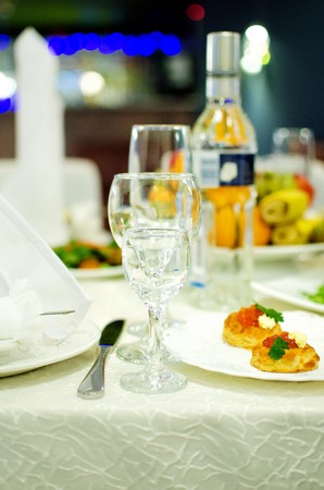 Empty wine glasses for alcoholic drinks and snacks stand on the served table.の写真素材