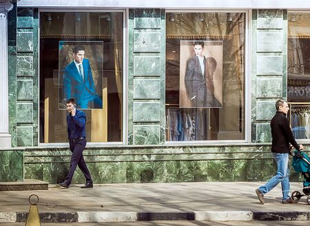 Saratov, Russia- April 26, 2015: Men walk down the street near the men's clothing store in Saratov.のeditorial素材