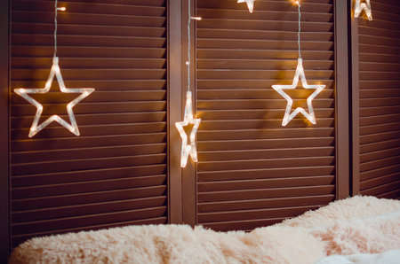 Beautiful glowing stars hang in the room, interior decoration.の写真素材