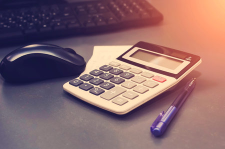 Calculator, pen, computer lie on the desk. Business Financing Accounting Banking Concept. Tinted...