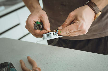 Close-up of a hand repairing an electrical outlet.の写真素材