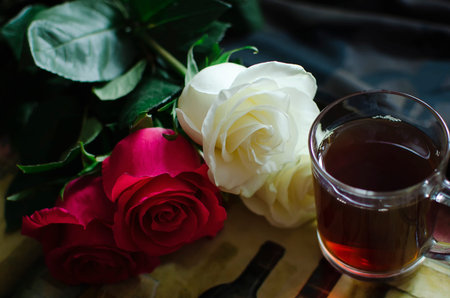 On the tray is a glass of tea and a bouquet of roses. Lifestyle concept.