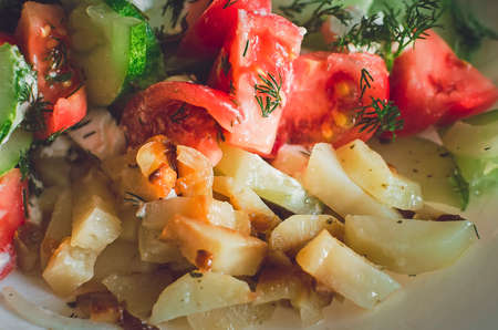 Fried potatoes with fresh vegetables.の写真素材