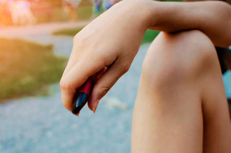 The girl holds an electronic cigarette in her hand, close-up.の写真素材