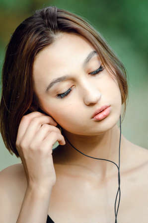 Cheerful young pretty girl listening music in headphones. Closed eyes.の写真素材
