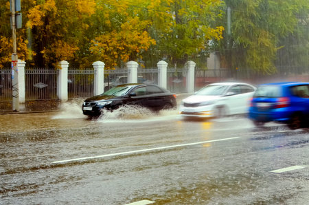 Saratov, Russia- September 03, 2021: Cars drive at high speed through puddles in the rain. Blurred...