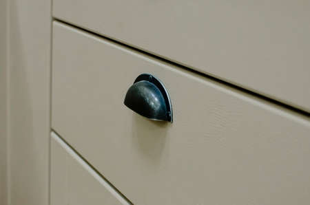 Fragment of a kitchen facade with a metal handle in a classic style.の写真素材