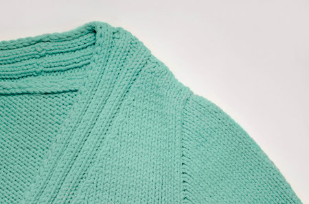Fragment of the collar of a green knitted sweater.
