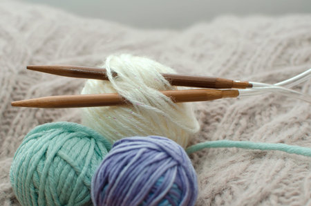 Cozy homely atmosphere. Female hobby knitting. Yarn in warm colors. The beginning of the process of...