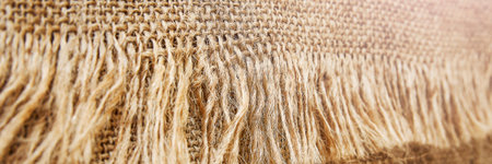 Panoramic sackcloth background with tassels. Close-up, selective focus.